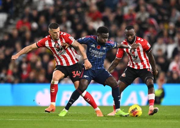 Bukayo Saka of Arsenal (centre) fends off Granit Xhaka of Sunderland (left) and Lutsharel Geertruida of Sunderland Sunderland v Arsenal, Premier League, Football, Stadium of Light, Sunderland, UK - 08 Nov 2025Sunderland Stadium of Light United Kingdom EDITORIAL USE ONLY No use with unauthorised audio, video, data, fixture lists, club league logos or live services. Online in-match use limited to 120 images, no video emulation. No use in betting, games or single club league player publications.  Copyright: xRichardxLee Shutterstockx 15702163ab