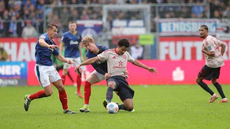 Foto : Emmanuel IYOHA (Fortuna) kommt zu Fall gegen Lasse Rosenbohm (Kiel) und links ... Stefan SCHWAB (Kiel) Fussball 2. Bundesliga , 12. Spieltag am So. 09.11.2025 Holstein Kiel - Fortuna Düsseldorf