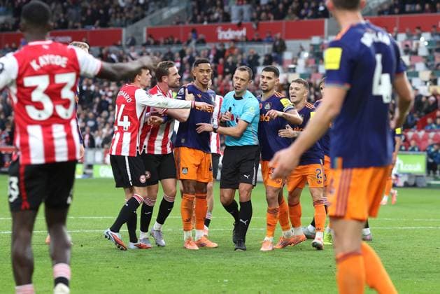 Brentford v Newcastle 09 November 2025, London - Premier League Football - Brentford v Newcastle United - Players surround referee Stuart Attwell as he shows a yellow card to Dango Ouattara of Brentford for diving - Photo: Charlotte Wilson Offside. London UK Copyright: xCharlottexWilsonx xOffsidexOffside