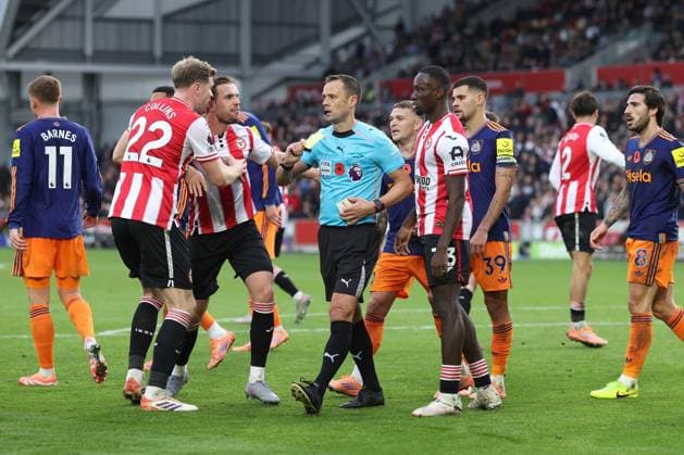 Brentford v Newcastle 09 November 2025, London - Premier League Football - Brentford v Newcastle United - Players surround referee Stuart Attwell as he shows a yellow card to Dango Ouattara of Brentford for diving - Photo: Charlotte Wilson Offside. London UK Copyright: xCharlottexWilsonx xOffsidexOffside