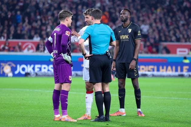 Referee Schiedsrichter Harm Osmers im Gespraech Finn Dahmen 1 (FC Augsburg) und Atakan Karazor 16 (VfB Stuttgart) mit Chrislain Matsima 5 (FC Augsburg), VfB Stuttgart vs. FC Augsburg, Fussball, Maenner, DFL, Bundesliga, Saison 2025 2026, MHP Arena, 10. Spieltag, 09.11.2025 Stuttgart Baden-Wuerttemberg Deutschland