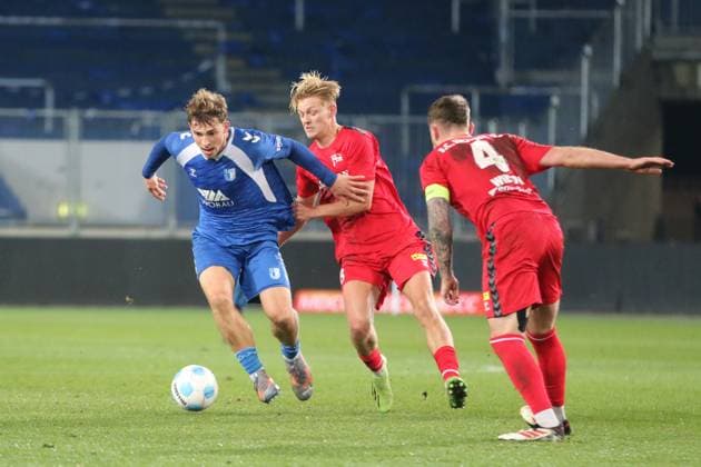 11.11.2025 Fußball Herren 2025 2026 Regionalliga Nordost 15. Spieltag 1. FC Magdeburg II U23 - FC Hertha 03 Zehlendorf Avnet Arena Magdeburg Jules Hasenberg (Zehlendorf, mitte) zieht Joonas Frenzel (FCM, links) am Trikot. Jake Robert Wilton (Zehlendorf, rechts) schaut zu. Magdeburg Sachsen-Anhalt Deutschland