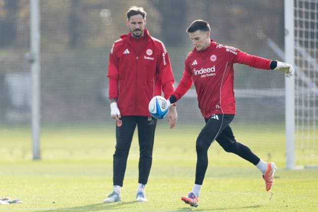Training Eintracht Frankfurt Torwart Michael Zetterer (Eintracht Frankfurt, 23) und Torwart Jens Grahl (Eintracht Frankfurt, 33) übern unter Anleitung von Rugbyspieler Anton Segner den Kick mit einem Rugbyball. Training von Eintracht Frankfurt am 12. November 2025 im Deutsche Bank Park in Frankfurt am Main., Frankfurt am Main Hessen Deutschland Deutsche Bank Park