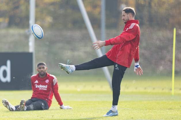 Training Eintracht Frankfurt Torwart Jens Grahl (Eintracht Frankfurt, 33) versucht einen Rugbyball zu kicken. Linksd beobachtet ihn Torwart Kaua Santos (Eintracht Frankfurt, 40). Training von Eintracht Frankfurt am 12. November 2025 im Deutsche Bank Park in Frankfurt am Main., Frankfurt am Main Hessen Deutschland Deutsche Bank Park