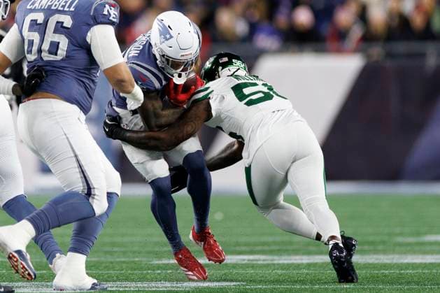 New England Patriots running back TreVeyon Henderson, left is tackled by New York Jets linebacker Quincy Williams, right, during the first half at Gillette Stadium in Foxborough, Massachusetts on Thursday, November 13, 2025.  BOP20251113010 CJxGUNTHER