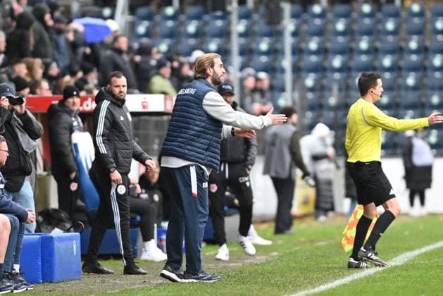 RECORD DATE NOT STATED Ronny Ermel (999; SV Babelsberg 03) gibt an der Seitenlinie Anweisungen, während Claus-Dieter Wollitz (999; FC Energie Cottbus) und Nico Hinz (998; SV Babelsberg 03) im Hintergrund stehen. Der Schiedsrichter leitet das Spiel. Trainer an der Seitenlinie Copyright: xSpeedshotx
