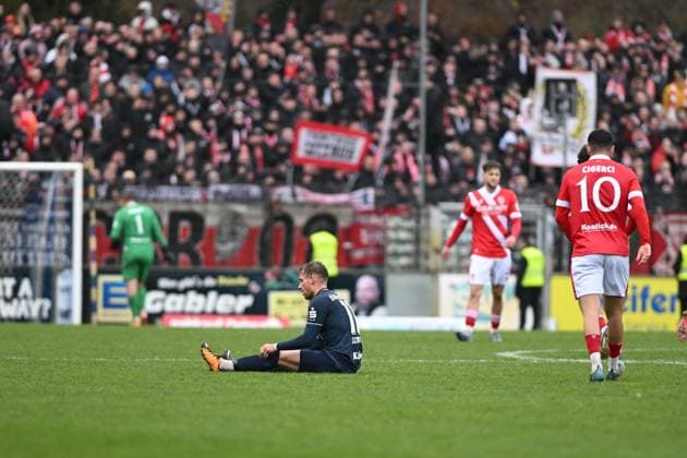 RECORD DATE NOT STATED Tino Schmidt (11; SV Babelsberg 03) sitzt verletzt auf dem Boden, während Tolcay Cigerci (10; FC Energie Cottbus) und weitere Spieler von FC Energie Cottbus vorbeigehen Spieler sitzt verletzt Copyright: xSpeedshotx
