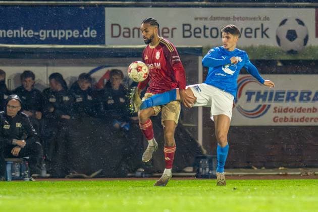 Fussball, Regionalliga Nord, BW Lohne - 1.FC Phönix Lübeck, 19. Spieltag, Spielzeit 2025 2026, 15.11.2025 Benjamin Luis (1.FC Phönix Lübeck 24) mit Luca Zander (Blau-Weiss Lohne 4) , Lohne Heinz-Dettmer-Stadion Niedersachsen Deutschland