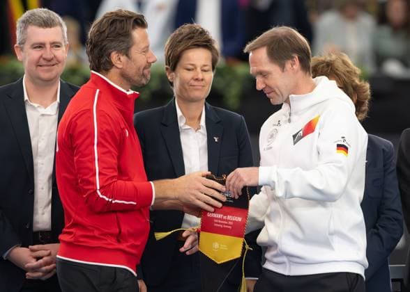 Billie Jean King Cup 2025 Play-Offs, TC Ismaning, Muenchen, Deutschland, Team Germany und Team Belgium Belgien, R-L. Team Belgien Captain Wim Fissette und Team Germany Captain Rainer Schuettler tauschen Wimpel Tennis - Billie Jean King Cup 2025 - ITF Billie Jean King Cup - TC Ismaning - Ismaning - Bayern - Deutschland - 16 November 2025. Copyright: xJuergenxHasenkopfx