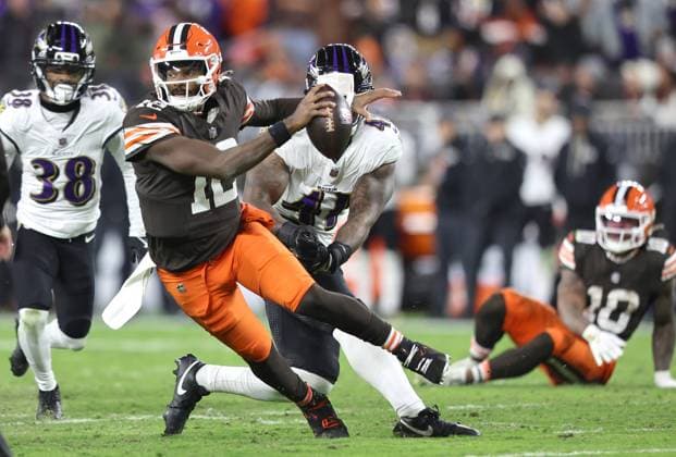 Cleveland Browns Shedeur Sanders (12) scrambles away from Baltimore Ravens Dre Mont Jones (41) during the third quarter at Huntington Bank Field in Cleveland, Ohio on Sunday, November 16, 2025.  CLE20251116129 AARONxJOSEFCZYK