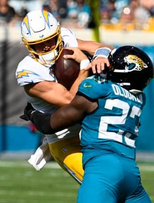 Chargers Quarterback Justin Herbert is tackled after scrambling in the first quarter as Los Angeles competes against Jacksonville at EverBank Stadium in Jacksonville, Florida on Sunday November 16, 2025. The Jaguars defeated the Chargers 35-6.  JAX20251116004r JOExMARINO