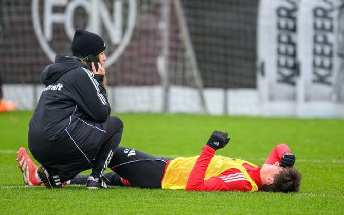 17.11.2025 - SpVgg Greuther Fürth Fuerth e.V. - Mitgliederversammlung Jahreshauptversammlung - - xwoxzix - 18.11.2025 - Fussball - 2. Fussball - Bundesliga - Saison 2025 2026 - 1. FC Nürnberg Nuernberg FCN ( Club ) - Training - Sportfoto Zink - xwoxzix - Eryk Grzywacz (19, 1. FC Nürnberg FCN ) angeschlagen verletzt Verletzung - Anika Monatzetter (Physiotherapeutin 1. FC Nürnberg FCN ) am Telefon Handy Smartphone