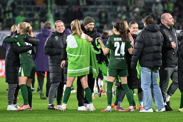 Fußball I Frauen I Saison 2025-2026 I Champions League I 4. Spieltag I VfL Wolfsburg - Manchester United, ManU I 19.11.2025 Stephan Lerch (Trainer, VfL Wolfsburg) (Mitte, mit Mütze) lächelt und drückt Torschützin Vivien Endemann (25, VfL Wolfsburg) (mit Decke) Wolfsburg Volkswagen Arena Niedersachsen Deutschland Copyright: xLobeca InesxHähnelx