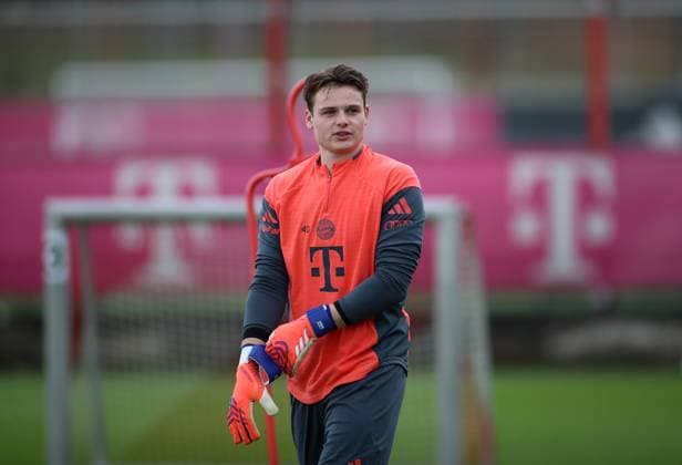 Fussball, Herren, Saison 2025 2026, FC Bayern München, Training Jonas Urbig (FC Bayern München) zieht sich seine Handschuhe an mit Blick nach links