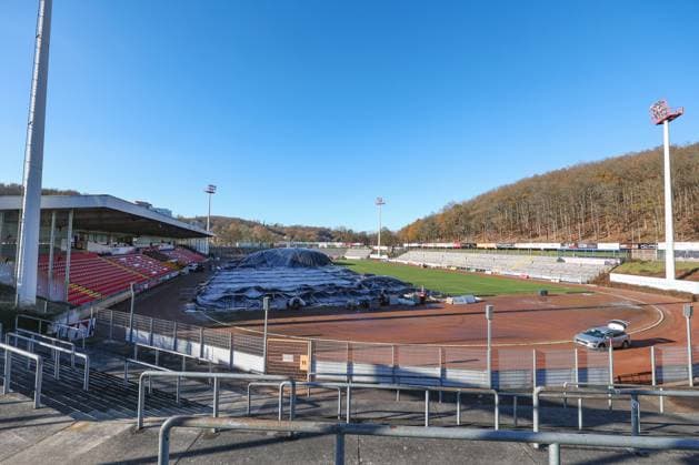 Das Leimbachstadion, Heimstaette (Heimstätte) der Sportfreunde Siegen. Vor der Haupttribuene (Haupttribüne) wird mit Waerme (Wärme), Warmer Luft unter eine Folie der Rasen aufgetaut. Es wird alles versucht, damit das Heimspiel am morgigen Samstag gegen den SC Fortuna Koeln (Köln) stattfinden kann. Fussball Regionalliga West, Leimbachstadion, Sportfreunde Siegen am 21.11.2025 in Siegen Deutschland.