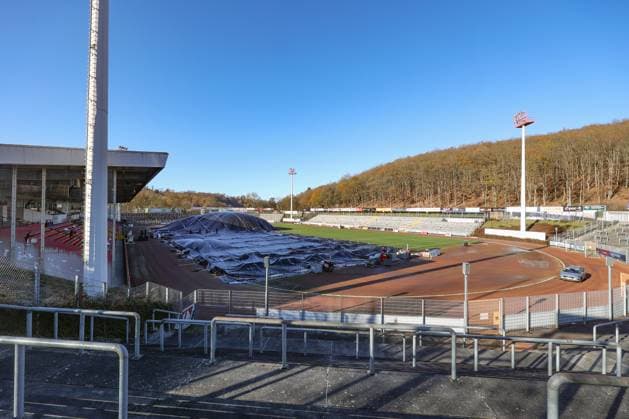 Das Leimbachstadion, Heimstaette (Heimstätte) der Sportfreunde Siegen. Vor der Haupttribuene (Haupttribüne) wird mit Waerme (Wärme), Warmer Luft unter eine Folie der Rasen aufgetaut. Es wird alles versucht, damit das Heimspiel am morgigen Samstag gegen den SC Fortuna Koeln (Köln) stattfinden kann. Fussball Regionalliga West, Leimbachstadion, Sportfreunde Siegen am 21.11.2025 in Siegen Deutschland.