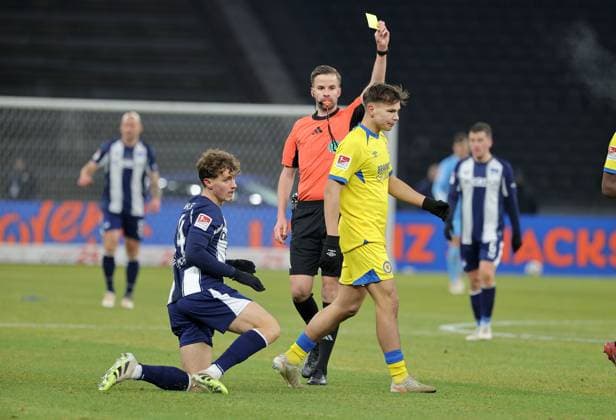 Schiedsrichter Michael Bacher zeigt gelbe Karte für Max Marie nach Foulspiel an Maurice Krattenmacher Fußball Fussball DFL 2.Bundesliga Herren 13. Spieltag Saison 2025 2026 21.11.2025 Hertha BSC Berlin vs. Eintracht Braunschweig BTSV DFL regulations prohibit any use of photographs as image sequences and or quasi-video