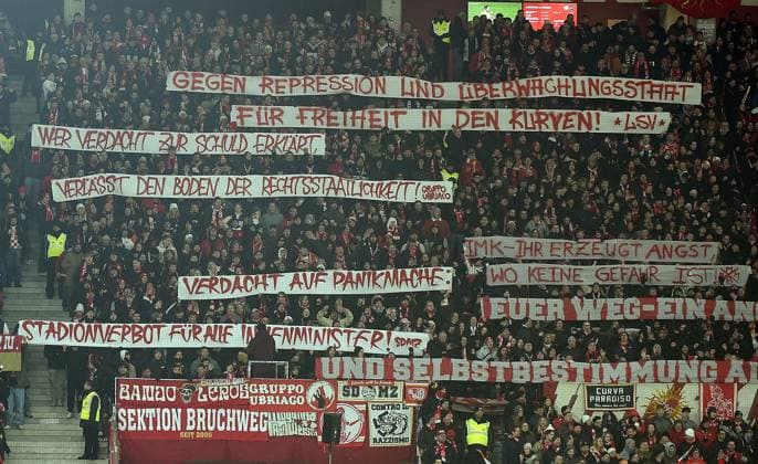 21.11.2025, xhbx, Fussball 1.Bundesliga, FSV Mainz 05 - TSG Hoffenheim v.l. Fans, Stimmung, Schals, Fahne, Banner, Fanproteste von FSV Mainz 05 (DFL DFB REGULATIONS PROHIBIT ANY USE OF PHOTOGRAPHS as IMAGE SEQUENCES and or QUASI-VIDEO) Mainz