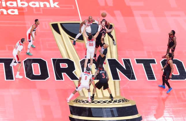 (251122) -- TORONTO, Nov. 22, 2025 -- Jakob Poeltl (top, C) of Toronto Raptors jumps the ball with Tristan Vukcevic of Washington Wizards during the 2025-2026 NBA, Basketball Herren, USA Cup group match between Toronto Raptors and Washington Wizards in Toronto, Canada, Nov. 21, 2025. (Photo by Xinhua) (SP)CANADA-TORONTO-NBA CUP-WIZARDS VS RAPTORS ZouxZheng 