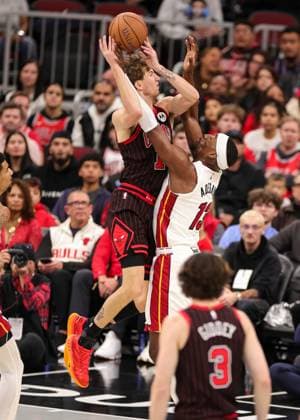 (251122) -- CHICAGO, Nov. 22, 2025 -- Matas Buzelis (top) of Chicago Bulls goes to the basket against Bam Adebayo of Miami Heat during the 2025-2026 NBA, Basketball Herren, USA Cup group match between Chicago Bulls and Miami Heat in Chicago, the United States, on Nov. 21, 2025. (Photo by Xinhua) (SP)U.S.-CHICAGO-BASKETBALL-NBA CUP-BULLS VS HEAT JoelxLerner 