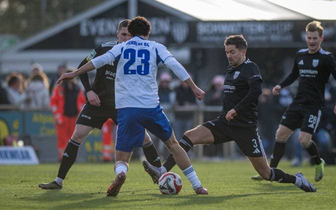 Fussball, Saison 2025 2026, Regionalliga West, 22.11.2025, 16. Spieltag, Herren, 1.FC Bocholt (schwarz) vs. FC Schalke 04 U23 (weiss) v.l.: Dawyn-Paul Donner (1.FC Bocholt), Jakob Sachse (FC Schalke 04 U23), Julian Riedel (1.FC Bocholt), Bocholt Stadion am Huenting Nordrhein-Westfalen Deutschland
