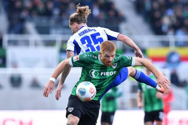 Fußball 2. Bundesliga 13. Spieltag SC Preußen Münster - FC Schalke 04 am 22.11.2025 im LVM-Preußenstadion in Münster Mikkel Kirkeskov Andersen ( Münster ), vorne - Mika Tom Wallentowitz ( Schalke ), hinten DFL regulations prohibit any use of photographs as image sequences and or quasi-video.