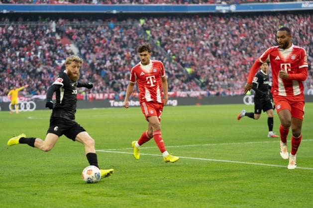 Jan-Niklas Beste (19 Freiburg) , Tom Bischof (20 Bayern) und Jonathan Tah (4 Bayern) in Aktion beim Bundesligaspiel FC Bayern München - SC Freiburg am 22.11.2025.