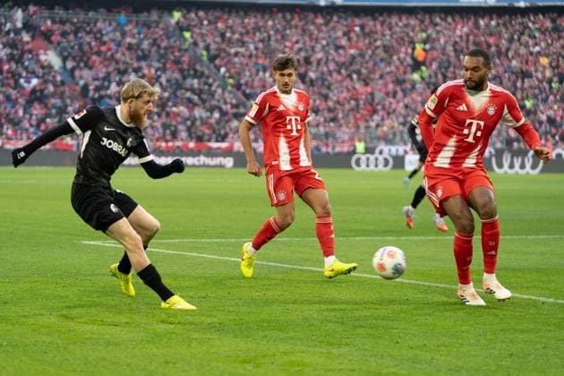 Jan-Niklas Beste (19 Freiburg) , Tom Bischof (20 Bayern) und Jonathan Tah (4 Bayern) in Aktion beim Bundesligaspiel FC Bayern München - SC Freiburg am 22.11.2025.