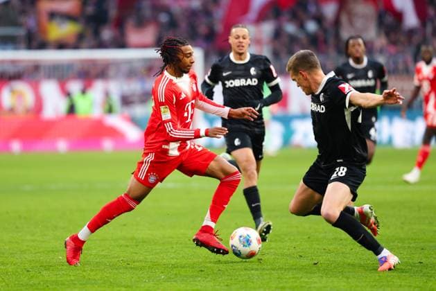 Michael Olise (17, FC Bayern München) und Matthias Ginter (28, SC Freiburg) beim Spiel zwischen FC Bayern München v SC Freiburg, Fußball, Herren, Bundesliga, 2025 2026, 11.Spieltag am 22.11.2025 in München, Allianz-Arena. DFL and DFB regulations prohibit any use of photographs as image sequences and or quasi-video. Bayern Deutschland