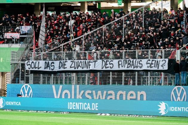 Deutschland, Fußball, 1. Bundesliga 2025 26, 11. Spieltag - VfL Wolfsburg gegen Bayer Leverkusen - Volkswagen Arena Wolfsburg: Protestbanner Gästeblock Bayer Leverkusen Soll das die Zukunft des Fußballs sein? Copyright: xJamesxZabelx
