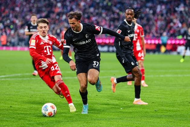 Lennart Karl (42, FC Bayern München) und Max Rosenfelder (37, SC Freiburg) beim Spiel zwischen FC Bayern München v SC Freiburg, Fußball, Herren, Bundesliga, 2025 2026, 11.Spieltag am 22.11.2025 in München, Allianz-Arena. DFL and DFB regulations prohibit any use of photographs as image sequences and or quasi-video. Bayern Deutschland