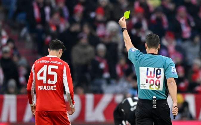 Schiedsrichter Referee Sven Jablonski mit Werbung fuer UEFA Frauen EURO 2029 als Kandidat zeigt Aleksandar Pavlovic FC Bayern Muenchen FCB (45) gelbe Karte gelb Verwarnung Gestik Geste FC Bayern Muenchen SC Freiburg SCF 22.11.2025 DFL REGULATIONS PROHIBIT ANY USE OF PHOTOGRAPHS AS IMAGE SEQUENCES AND OR QUASI-VIDEO FC Bayern Muenchen SC Freiburg SCF