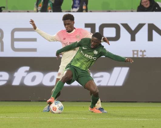 Sael Kumbedi (VfL Wolfsburg), Ernest Poku (Bayer 04 Leverkusen) Fussball, Herren, Saison 2025 2026, 1.Liga, Bundesliga, Volkswagenarena, VfL Wolfsburg gegen Bayer Leverkusen DFL REGULATIONS PROHIBIT ANY USE OF PHOTOGRAPHS AS IMAGE SEQUENCES AND OR QUASI-VIDEO.