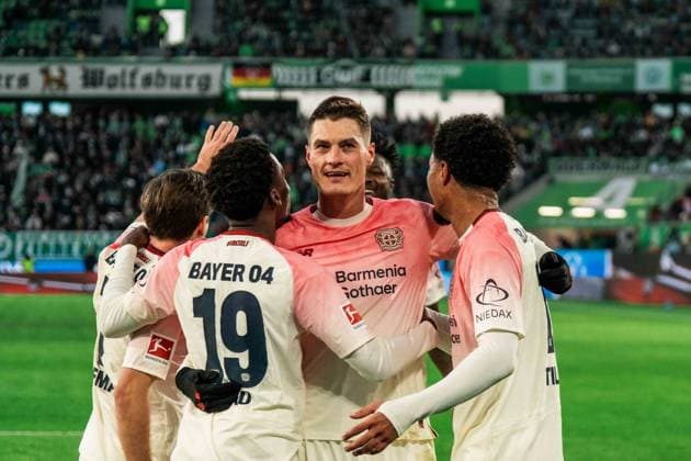 Deutschland, Fußball, 1. Bundesliga 2025 26, 11. Spieltag - VfL Wolfsburg gegen Bayer Leverkusen - Volkswagen Arena Wolfsburg: Patrik Schick (14, Bayer Leverkusen), Ernest Poku (19, Bayer Leverkusen) und Torschütze Malik Tillman (10, Leverkusen) Torjubel zum 3:0 Copyright: xJamesxZabelx