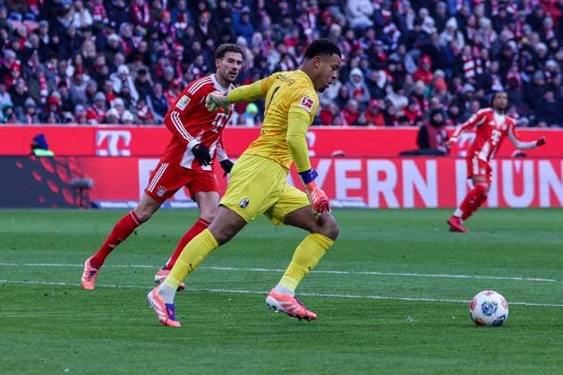 Noah Atubolu 1 (SC Freiburg) mit einem Abschlag, vor Leon Goretzka 8 (FC Bayern Muenchen), FC Bayern Muenchen vs. SC Freiburg, Fussball, Bundesliga, DFL, Saison 2025 2026, Hinrunde, 22.11.2025 DFB regulations prohibit any use of photographs as image sequences and or quasi-video Muenchen Bayern Deutschland