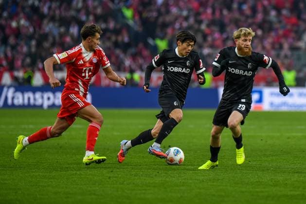 Tom Bischof (20 Bayern) , Yuito Suzuki (14 Freiburg) und Jan-Niklas Beste (19 Freiburg) in Aktion beim Bundesligaspiel FC Bayern München - SC Freiburg am 22.11.2025.