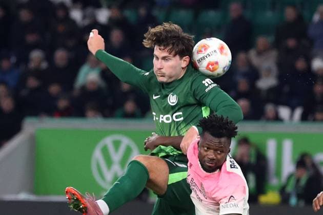 VfL vs. Leverkusen, 1. BL Wolfsburg, 22.11.2025, FUßBALL - VfL Wolfsburg vs. Bayer 04 Leverkusen, 1. BL, Saison 2025 26. Jonas Wind (VfL Wolfsburg), Edmond Tapsoba (Bayer 04 Leverkusen), Wolfsburg