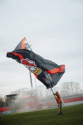 22.11.25, Frauen, Fussball, Google Pixel Frauen Bundesliga, Saison 2025 2026, Bayer 04 Leverkusen - SGS Essen, 11. Spieltag Ein Leverkusen Fan Volunteer schwenkt eine große Fahne auf dem Spielfeld Leverkusen Ulrich-Haberland-Stadion NRW Deutschland