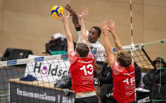 Volleyball, Saison 2025 2026, 2. Bundesliga Nord, 22.11.2025, 08. Spieltag, Herren, TuB Bocholt (weiss) vs. VV Human Essen (rot) v.l.: Simon Schroeder (VV Human Essen), Rudy Schneider (TuB Bocholt), Fynn Bach (VV Human Essen), Bocholt Sporthalle West Nordrhein-Westfalen Deutschland