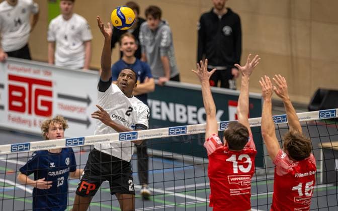 Volleyball, Saison 2025 2026, 2. Bundesliga Nord, 22.11.2025, 08. Spieltag, Herren, TuB Bocholt (weiss) vs. VV Human Essen (rot) v.l.: Rudy Schneider (TuB Bocholt), Simon Schroeder (VV Human Essen), Fynn Bach (VV Human Essen), Bocholt Sporthalle West Nordrhein-Westfalen Deutschland