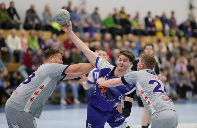 Deutschland - Kelkheim - Münster - 22.11.2025 Handball - Hessen - 3. Liga - Staffel Süd-West - Herren Saison 2025 2026 (12. Spieltag) TSG Münster (blau) - TSG Haßloch (grau) v.l. Sebastian Bösing (TSG Haßloch - 28), Jonas Schneider (TSG Münster - 5), Niklas Klein (TSG Haßloch - 24) TSG Münster - TSG Haßloch
