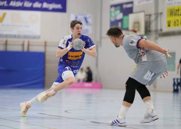 Deutschland - Kelkheim - Münster - 22.11.2025 Handball - Hessen - 3. Liga - Staffel Süd-West - Herren Saison 2025 2026 (12. Spieltag) TSG Münster (blau) - TSG Haßloch (grau) v.l. Lars Zelser (TSG Münster - 77), Sebastian Bösing (TSG Haßloch - 28) TSG Münster - TSG Haßloch