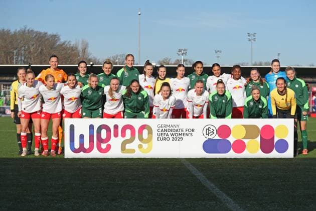 Google Pixel Frauen-Bundesliga, RB Leipzig - VfL Wolfsburg; 23.11.2025 Mannschaftsfoto mit beiden Teams mit Werbebande WE 29, Kandidatur zur Frauen-Fußball-EM 2029. Fußball, Google Pixel Frauen-Bundesliga, Saison 2025 2026, 11. Spieltag: RB Leipzig vs. VfL Wolfsburg am 23.11.2025, Trainingszentrum Cottaweg, Leipzig. DFB REGULATIONS PROHIBIT ANY USE OF PHOTOGRAPHS AS IMAGE SEQUENCES AND OR QUASI-VIDEO. Copyright: xBEAUTIFULxSPORTS JanxKaeferx