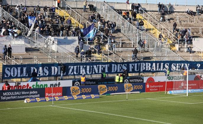 Fussball, Herren, 3.Liga, Saison 2025 2026, TSV 1860 München - 1.FC Saarbrücken, Grünwalder Stadion Banner in der Westkurve, TSV 1860, Soll das die Zukunft des Fussballs sein ?, Protest