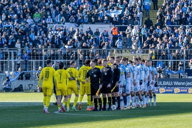 Die Spieler beider Teams beim Abklatschen vor der Partie, mit dabei das Schiedsrichtergespann GER, TSV 1860 Muenchen vs. 1. FC Saarbruecken, Fussball, 3. Bundesliga, 15. Spieltag, Saison 2025 2026, 23.11.2025. (DFL DFB REGULATIONS PROHIBIT ANY USE OF PHOTOGRAPHS as IMAGE SEQUENCES and or QUASI-VIDEO). GER, TSV 1860 Muenchen vs. 1. FC Saarbruecken, Fussball, 3. Bundesliga, 15. Spieltag, Saison 2025 2026, 23.11.2025. Muenchen Copyright: xEibner-Pressefoto HeikexFeinerx EP_HFR