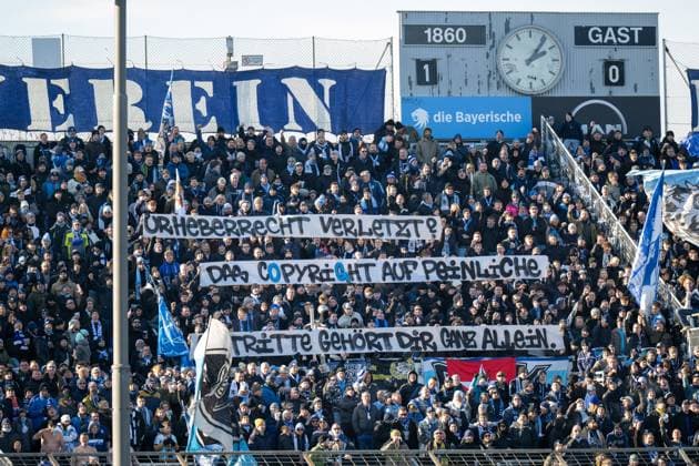 Fans mit dem Banner Urheberrecht É, TSV 1860 Muenchen vs. 1. FC Saarbruecken, 3. Liga, 15. Spieltag, 23.11.2025 DFB regulations prohibit any use of photographs as image sequences and or quasi-video Muenchen Bayern Deutschland
