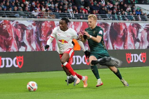 23.11.2025 Fußball Herren 2025 2026 Bundesliga 11. Spieltag RB Leipzig - SV Werder Bremen Red Bull Arena Leipzig Yan Diomande (Leipzig, weiß) im Laufduell mit Marco Grüll (Bremen, grün). Es fliegen zwei Tauben durch das Bild. Leipzig Sachsen Deutschland