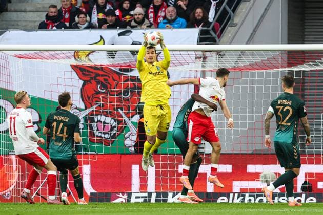 Torwart Mio Backhaus (Werder Bremen,30) gegen Christoph Baumgartner (RB Leipzig,14) - 1. Fussball Bundesliga Saison 2025-2026 Punktspiel RB Leipzig vs. Werder Bremen in der Red Bull Arena in Leipzig - Aktion,Fussball,Deutschland,Mann,Männer,23.11.2025