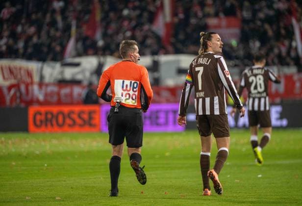 Fussball, Herren, Saison 2025 2026, 1. Bundesliga (11. Spieltag), FC St. Pauli - 1. FC Union Berlin, v. l. Schiedsrichter Tobias Stieler, Jackson Irvine (St. Pauli), Aktionsspieltag für Bewerbung um Frauen-EM 2029, 23.11. 2025, Copyright: xMatthiasxKochx