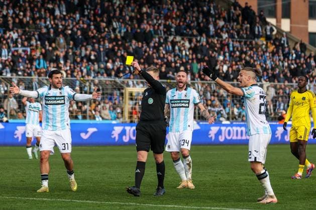 Referee Schiedsrichter Felix Weller gibt Lasse Wilhelm 18 (1. FC Saarbruecken), nicht im Bild, die gelbe Karte, Kevin Volland 31 (TSV 1860 Muenchen), Patrick Hobsch 34 (TSV 1860 Muenchen) und Sigurd Haugen 22 (TSV 1860 Muenchen) protestieren und fordern einen Platzverweis, TSV 1860 Muenchen vs. 1. FC Saarbruecken, Fussball, Dritte Liga, DFL, Saison 2025 2026, Hinrunde, 15. Spieltag, 23.11.2025 DFB regulations prohibit any use of photographs as image sequences and or quasi-video Muenchen Bayern Deutschland